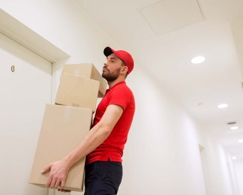 delivery-man-with-parcel-boxes-at-customer-door-P9JH3R6